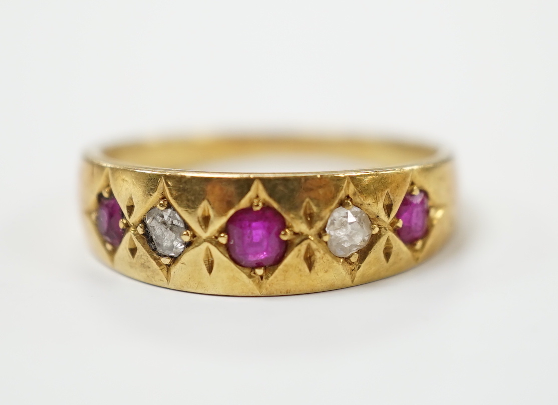 An early 20th century yellow metal ruby and diamond set five stone dress ring, size P